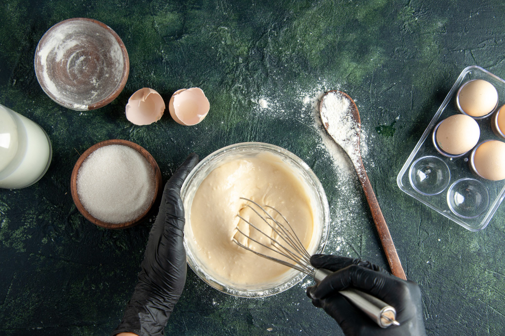top-view-female-cook-mixing-up-ingredients-making-dough-dark-surface